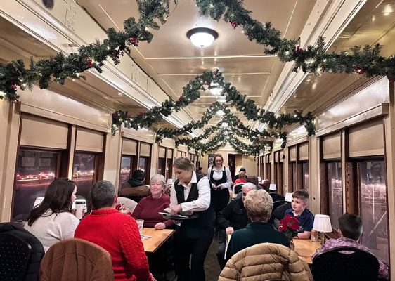 Guests enjoy breakfast with Santa aboard a festively decorated vintage train car.