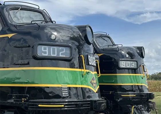 Two locomotives next to each other with a blue sky in the background. WCRR Film Flyer